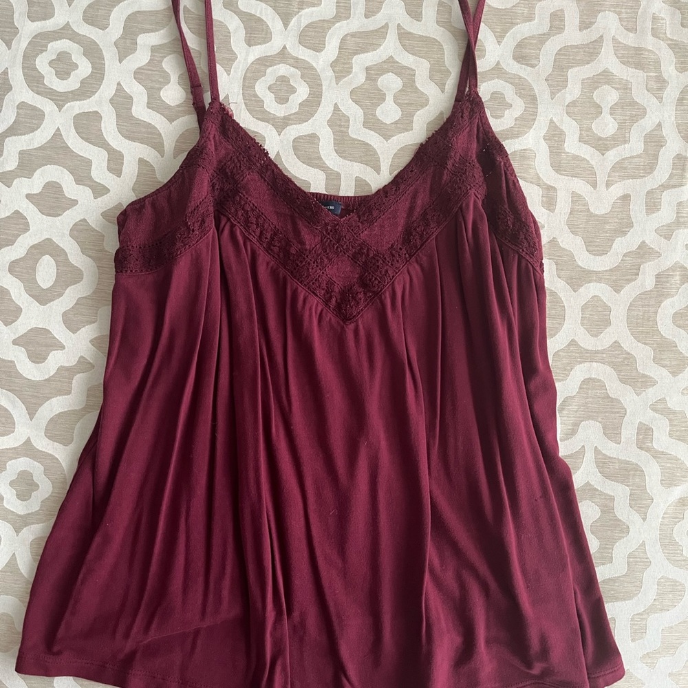 Maroon spaghetti strap flowy tank with lace detailing on the neckline